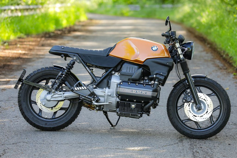 BMW K100 SE Roadster bike in vintage design parked on a scenic road, showcasing classic motorcycle styling and performance.