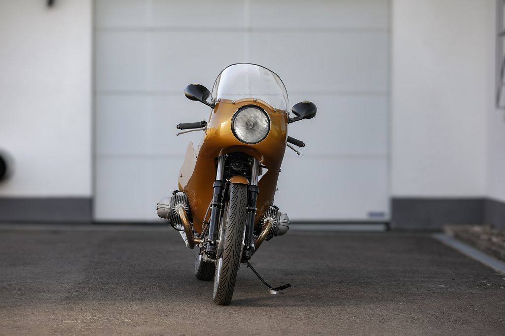 BMW Bobber SE Concept Bike in gold with classic racer design, showcased in a sleek garage setting.