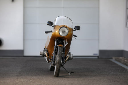 BMW Bobber SE Concept Bike in gold with classic racer design, showcased in a sleek garage setting.