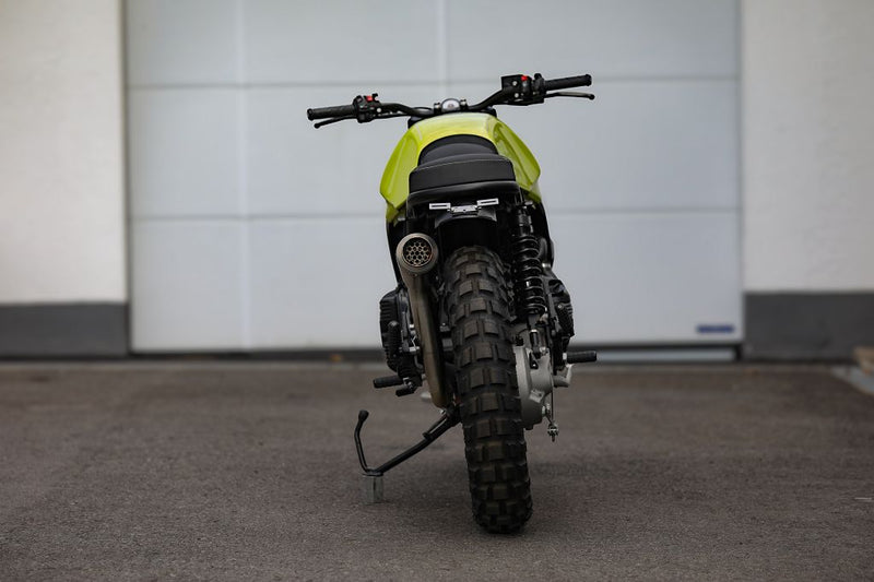 BMW K75 SE Scrambler concept bike in a rear view showing sleek design and rugged tires.