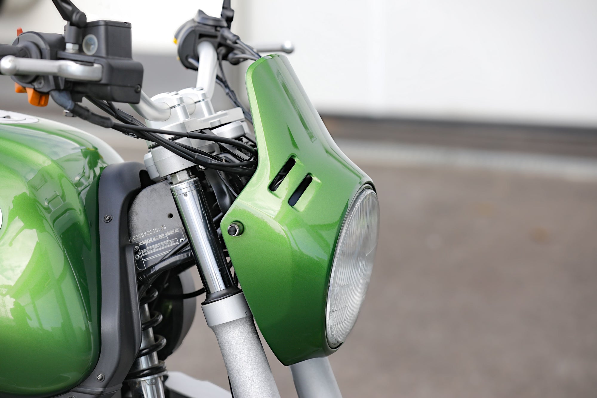 BMW R1100R Telelever motorcycle custom close-up of the green headlight and handlebars.