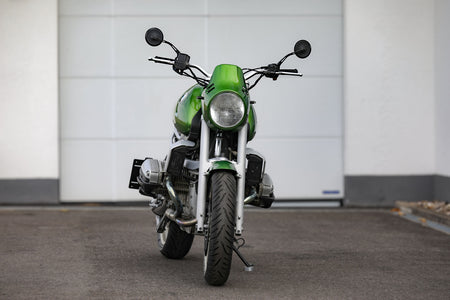 BMW R1100R Telelever motorcycle custom in green color, captured from the front view in a parking area.