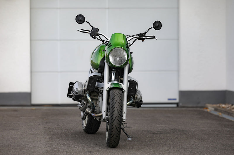 BMW R1100R Telelever motorcycle custom in green color, captured from the front view in a parking area.